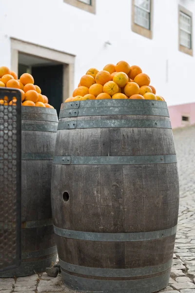 Orange Fruits over Big Oak wooden Barrels