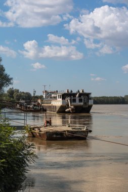 Bulut gökyüzü ile İtalya nehirde terk edilmiş teknede