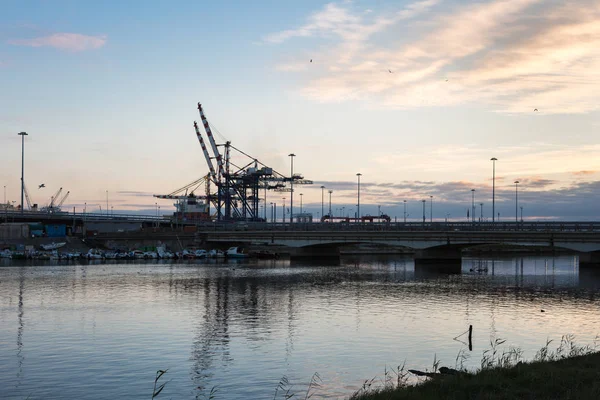 Terminal kontenerowy, stocznia i żurawie na zachodzie słońca i ich refl — Zdjęcie stockowe