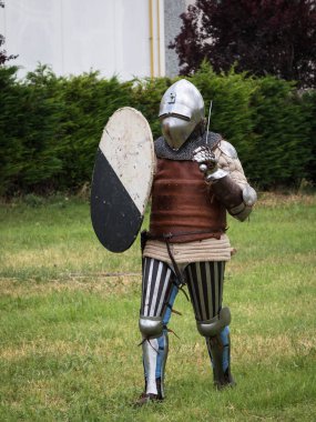 Knight gümüş kask, zırh, kalkan ve kılıç ile savaşta