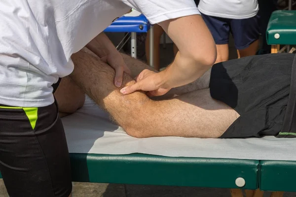 Massagem muscular de atleta após treino desportivo — Fotografia de Stock