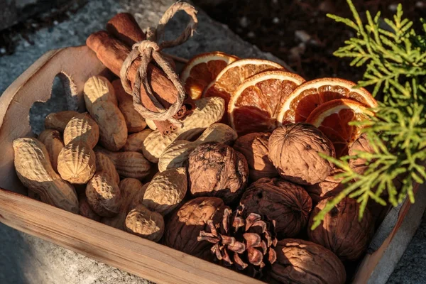 Little Wooden Box with Walnuts, Groundnut Seeds, Cinnamon Sticks and Dehydrated Orange Slices — Stock Photo, Image