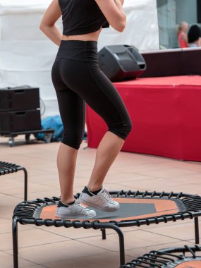 Mini trambolin egzersiz: Sınıf spor salonunda Fitness egzersiz yaparak kız