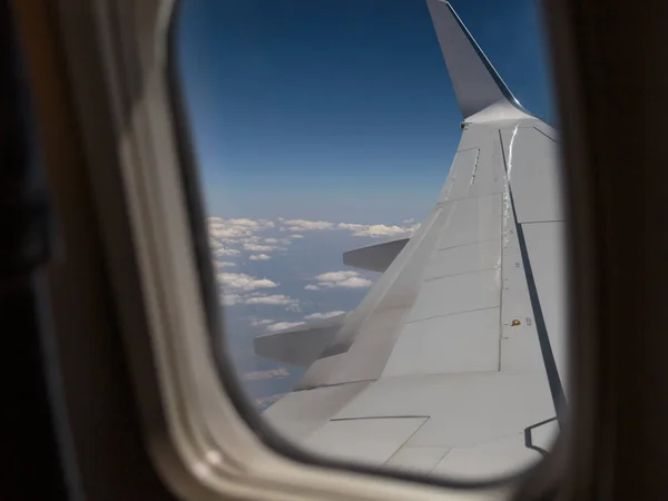 Mirando Fuera de una Ventana de una Cabina de Avión: Ala Blanca de Avión y Nubes — Foto de Stock