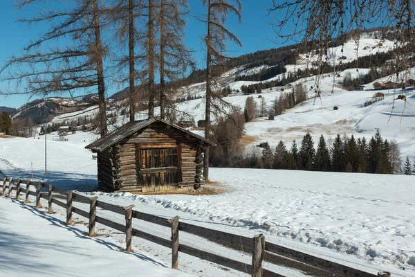 Piccola baracca in legno e recinzione tra gli alberi nella giornata invernale con neve fresca in montagna — Foto Stock