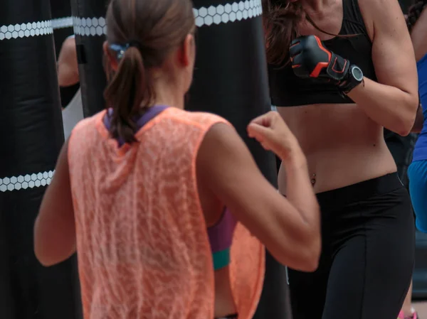 Νεαρά κορίτσια κάνουν γυμναστήριο και Πυγμαχία προπόνηση με μαύρο σάκο ζουμπάρισμα. — Φωτογραφία Αρχείου
