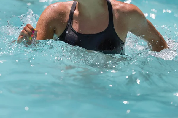 Mujer haciendo aeróbic acuático en una piscina al aire libre — Foto de Stock