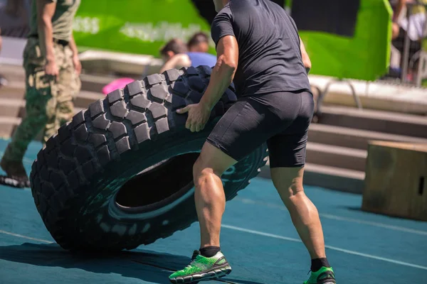 Muscular Man Lift Huge and Heavy Truck Tire