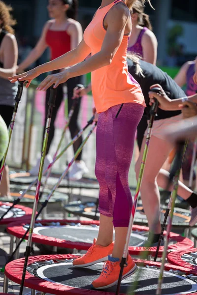 미니 트램 폴 린 운동 노르딕 워킹 스틱: 피트 니스 운동 체육관에서 야외 수업에서을 하 고 여자 — 스톡 사진