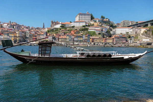 Tradycyjnej łodzi Rabelo na brzegu rzeki Douro i kolorowe fasady typowe domy Porto, Portugalia — Zdjęcie stockowe