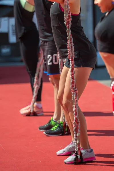 Fitness y Deporte: Gente haciendo ejercicio con cordones elásticos al aire libre en el gimnasio —  Fotos de Stock