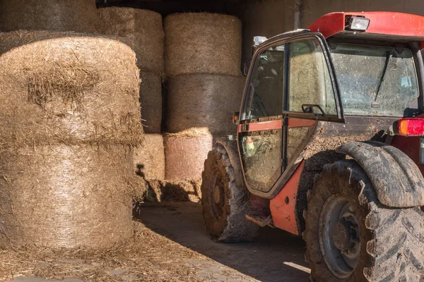 Runda buntar av höstackar och traktorn på plats på landsbygden — Stockfoto