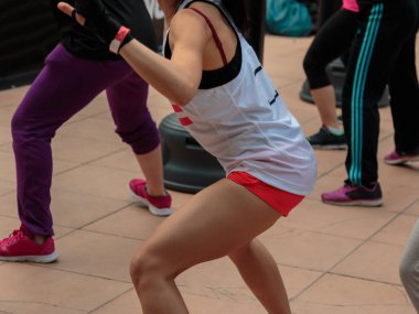 Şort ve beyaz kolsuz bluz ile genç kız: Fitness boks egzersiz kum torbası ile.