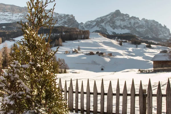 Houten hek, huizen en bergen met sneeuw in Europa: Dolomieten toppen van de Alpen voor de wintersport — Stockfoto