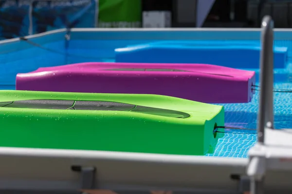 Tapete de fitness flutuante colorido em uma piscina ao ar livre — Fotografia de Stock