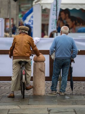 Arka iki yaşlı erkeklerde şehir sokak görünümü: bir bisiklet ve onun şemsiye ile diğer ayakta