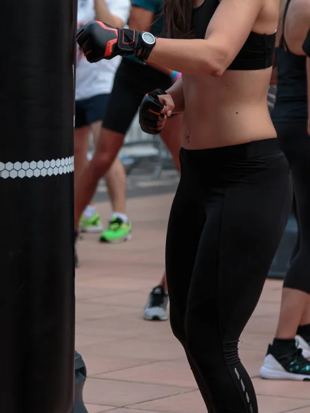 Rimini, Italien-juni 2016: unga flickor gör fitness och boxning Workout med svart boxnings påse — Stockfoto