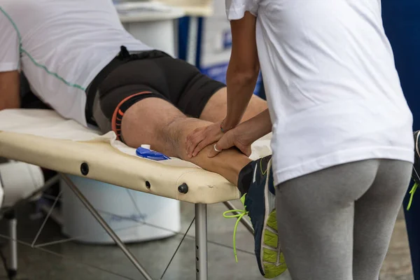 Masaje de los músculos de la pantorrilla del atleta después del entrenamiento deportivo — Foto de Stock