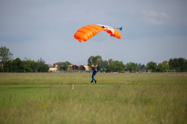 伞兵与橙色降落伞附近的地面准备着陆 — 图库照片