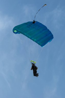 Reggio Emilia, İtalya - Mayıs 2017: Paraşütçü karşı açık mavi gökyüzü mavi paraşüt ile