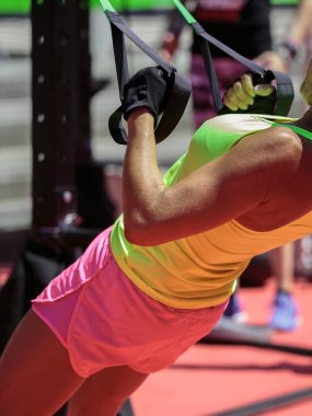 Spor salonunda açık çekiş eğitim donanımları ile egzersizleri yapıyor sınıfındaki kız