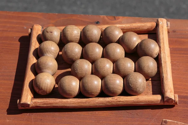 Kleine Holzkugeln auf dem Tisch im rechteckigen Feld: antikes Spiel — Stockfoto