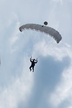 Paraşütçü karşı açık mavi gökyüzü beyaz paraşüt ile
