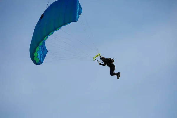 Parachutiste avec parachute bleu contre ciel bleu clair — Photo