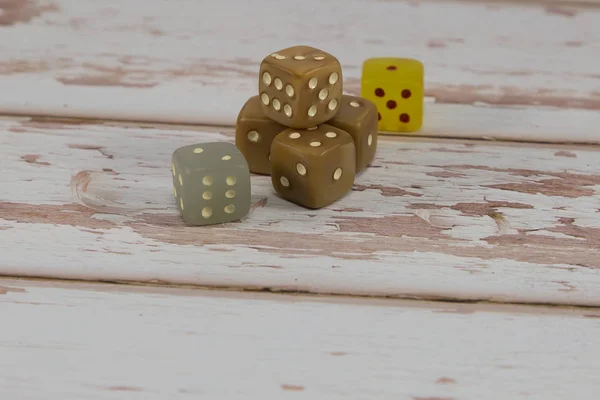 Plastikwürfel auf weißem Holztisch: Thema Glücksspiel — Stockfoto
