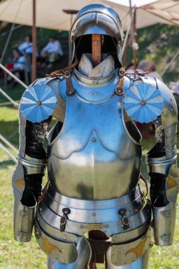 Kask yakınındaki beyaz çadır ile Ortaçağ metalik zırh