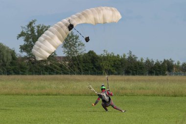 Reggio Emilia, İtalya - Mayıs 2017: Paraşütçü iniş için zemin hazırlama yakın beyaz paraşüt ile.