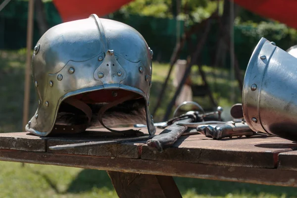 Close up of Medieval Silver Helmet on Wooden Table with Knight's Garment — Stock Photo, Image