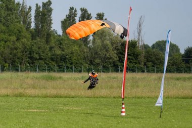 Paraşütçü iniş için zemin hazırlama yakın turuncu paraşüt ile
