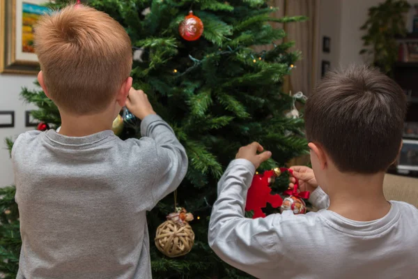 Çocuklar Noel ağacında topları ve süslemeleri asılı — Stok fotoğraf