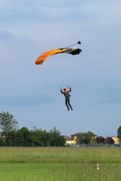 Paraşütçü karşı açık mavi gökyüzü turuncu paraşüt ile — Stok fotoğraf