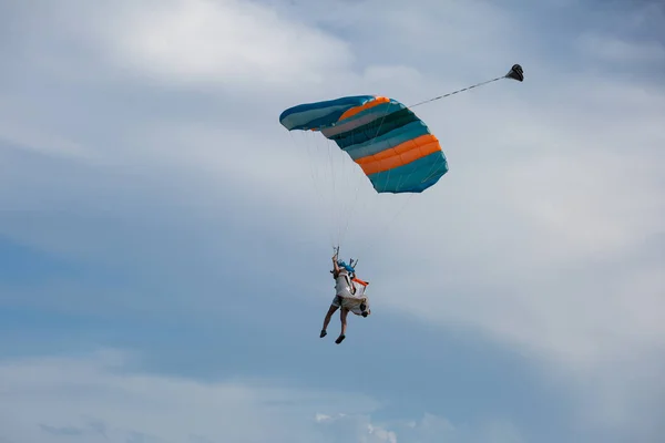 Парашютист с голубым парашютом против чистого голубого неба — стоковое фото