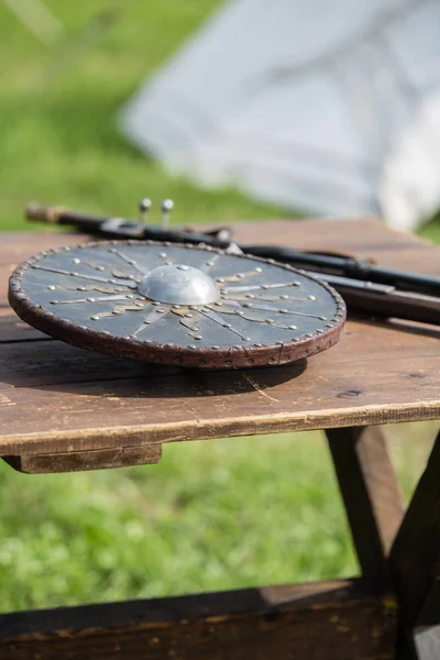 Escudo circular y metálico sobre tabla de madera: armaduras y armas metálicas medievales — Foto de Stock