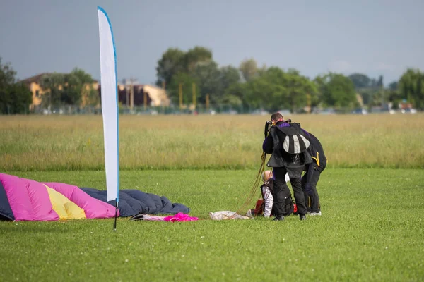 Instructors Help Old Parachutist Man on the Ground after Launch