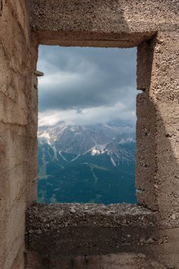 Bulutlu gökyüzü ve İtalyan Dolomites Alps içinde bir pencere görünümünden dağlar