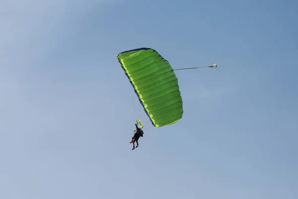 Paracadutisti: istruttore e principiante con paracadute verde contro Clear Blue Sky — Foto Stock