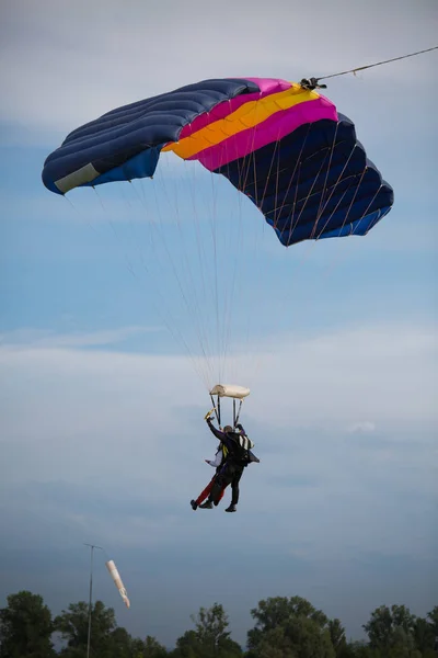 Paraşüt: açık mavi gökyüzü karşı mavi paraşüt ile eğitmen ve acemi — Stok fotoğraf