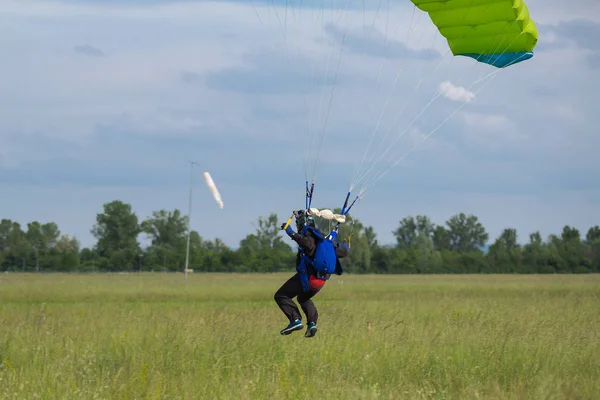 伞兵与绿色降落伞接近地面准备着陆 — 图库照片