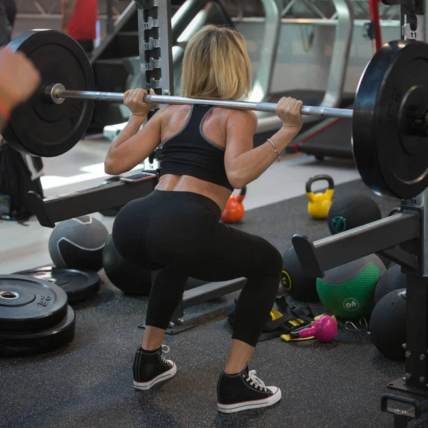 Allenamento fitness in palestra: donna che fa esercizi in classe all'aperto con bilanciere e pesi — Foto Stock