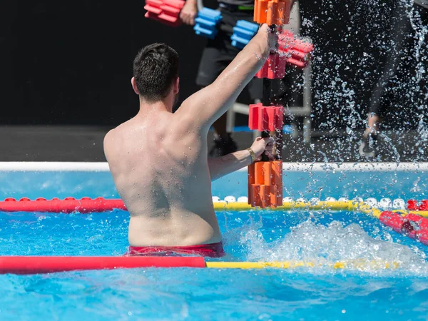 Αγόρι κάνει αεροβική νερού με πλωτή πισίνα Dumbbells Εξωτερική σε μια πισίνα — Φωτογραφία Αρχείου