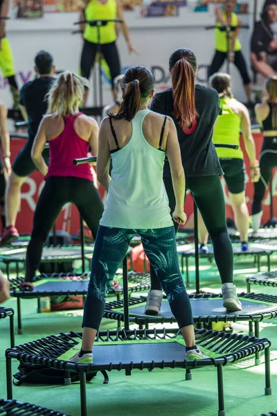 Mini Rebounder Workout - Meninas fazendo Fitness Exercício na classe no ginásio com música e professor no palco — Fotografia de Stock