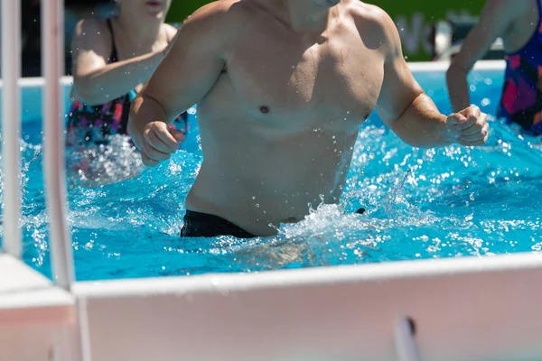 Menschen machen Wassergymnastik im Freien in einem Schwimmbad — Stockfoto