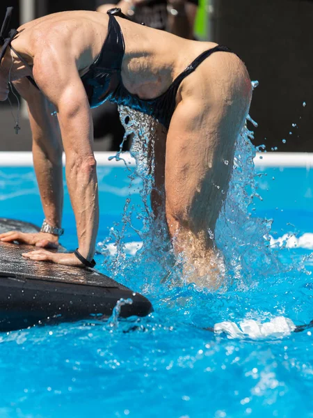 옥외 수영장에 떠 있는 건강용 매트 위에서 운동하는 소녀 — 스톡 사진