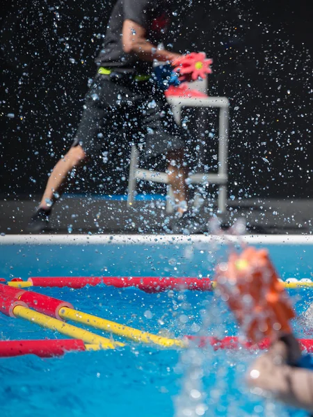 Niño haciendo aeróbic acuático con piscina flotante sombrillas al aire libre en una piscina — Foto de Stock