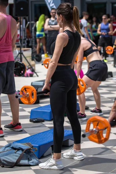 Meninas fazendo exercícios de levantamento de peso no ginásio ao ar livre com plataforma de passo: Treino de fitness . — Fotografia de Stock