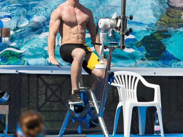 Aqua Gym: instruktor aerobiku i fitness na oczach grupy osób podczas ćwiczeń wodnych na rowerze — Zdjęcie stockowe
